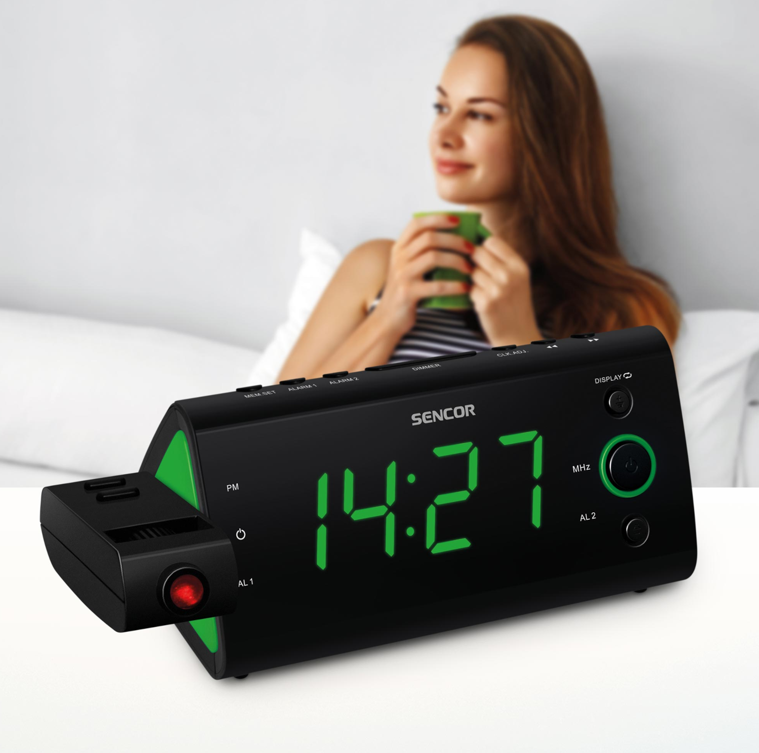 Egy digitális ébresztőóra, a háttérben homályosan egy bögrét tartó nővel.