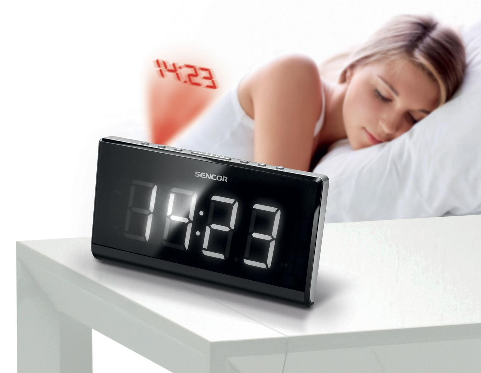 Egy digitális óra 14:23-at mutat, egy alvó nővel az elmosódott háttérben.