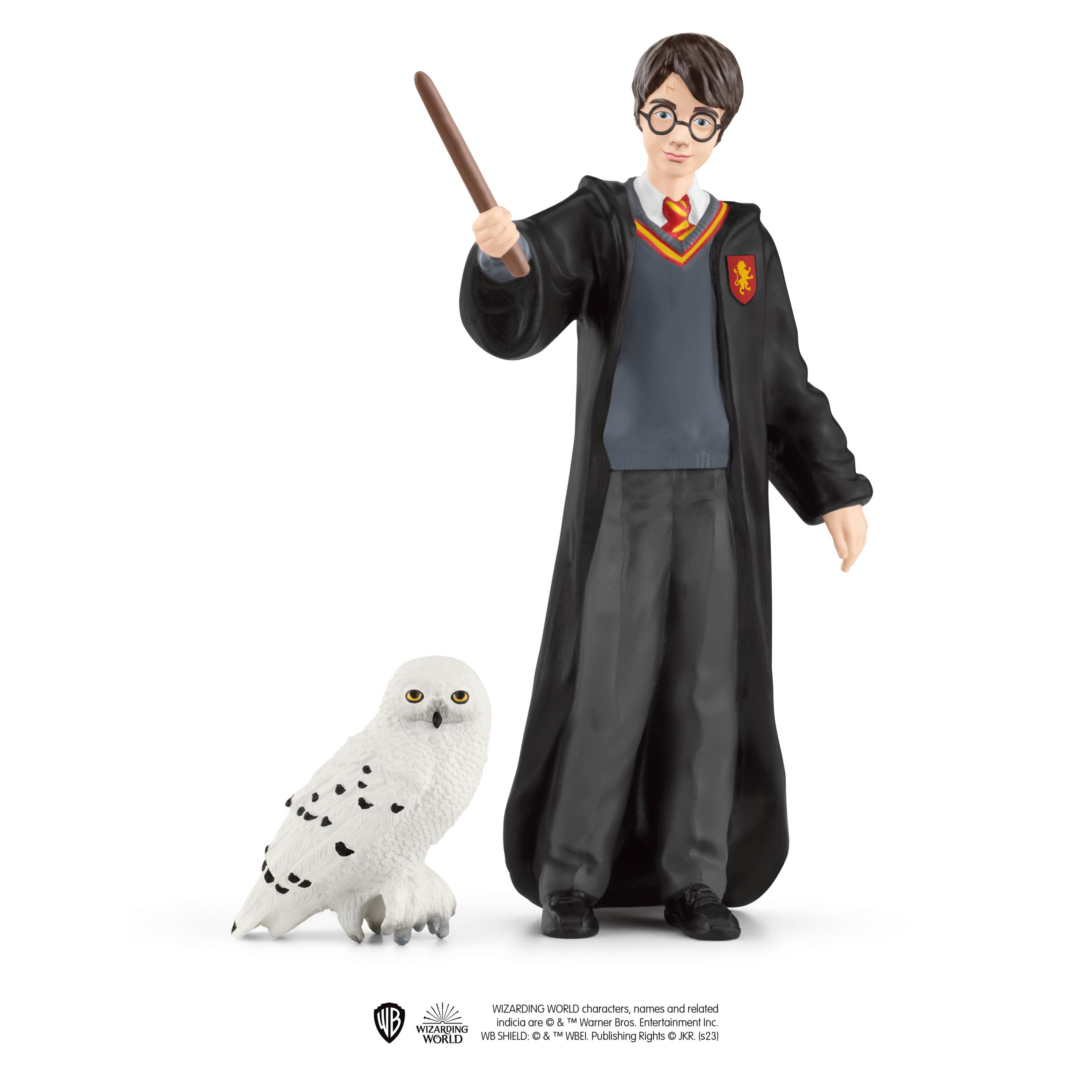 Harry Potter Figur mit Zauberstab neben einer Eule. Studioaufnahme mit weißem Hintergrund.
