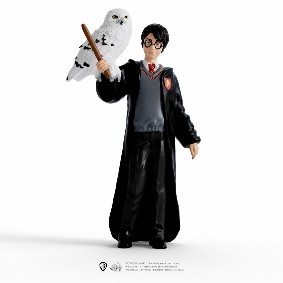 Harry Potter Figur mit einer Schnee-Eule. Trägt Roben und eine Brille.