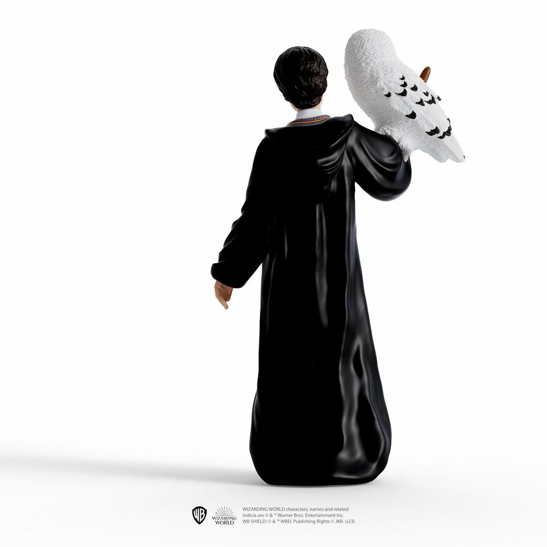 Eine Statue einer Person in schwarzer Robe mit einer weißen Eule auf der Schulter, weißer Hintergrund.