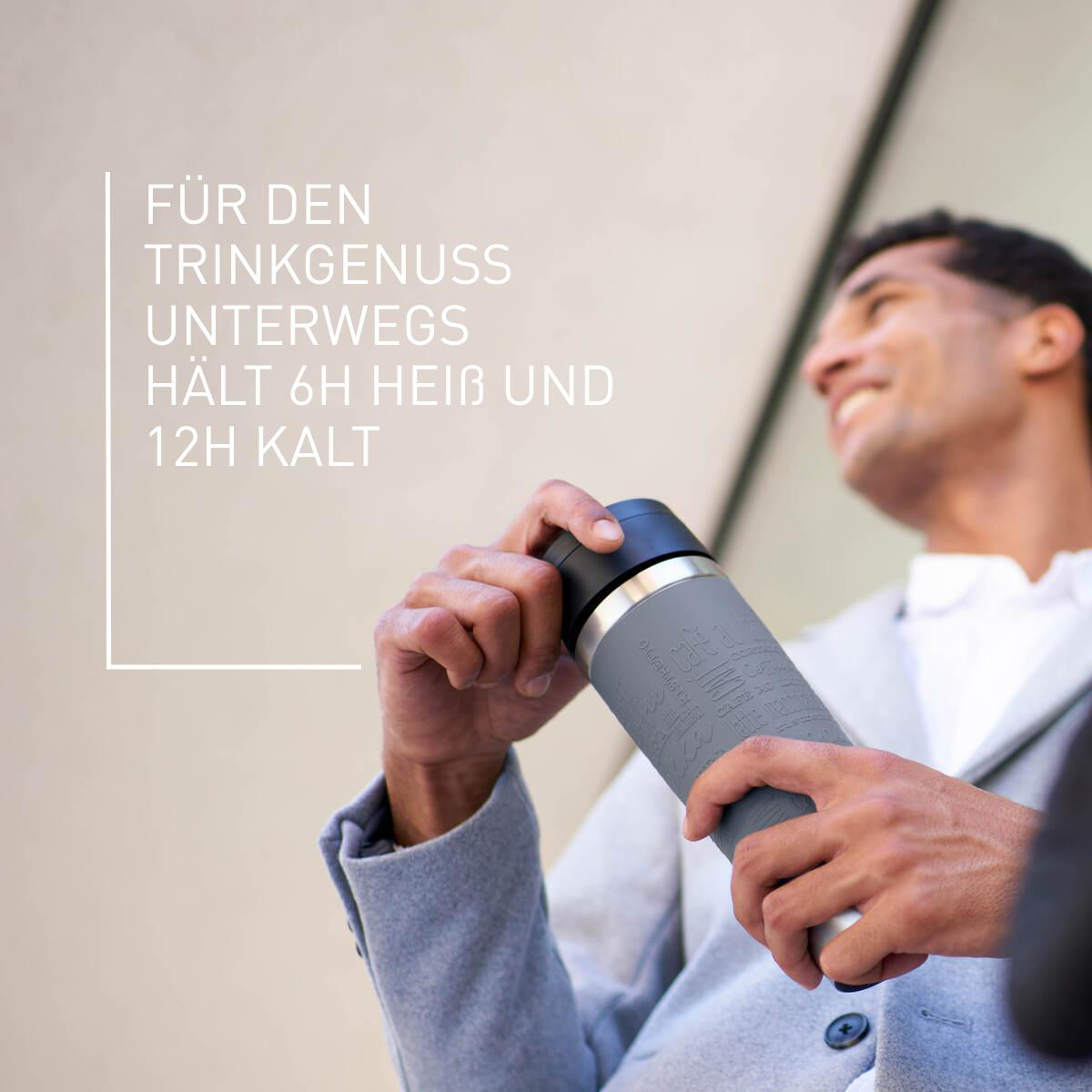 Mann hält eine grau-schwarze Thermoskanne. Text auf Deutsch im Bild sichtbar.