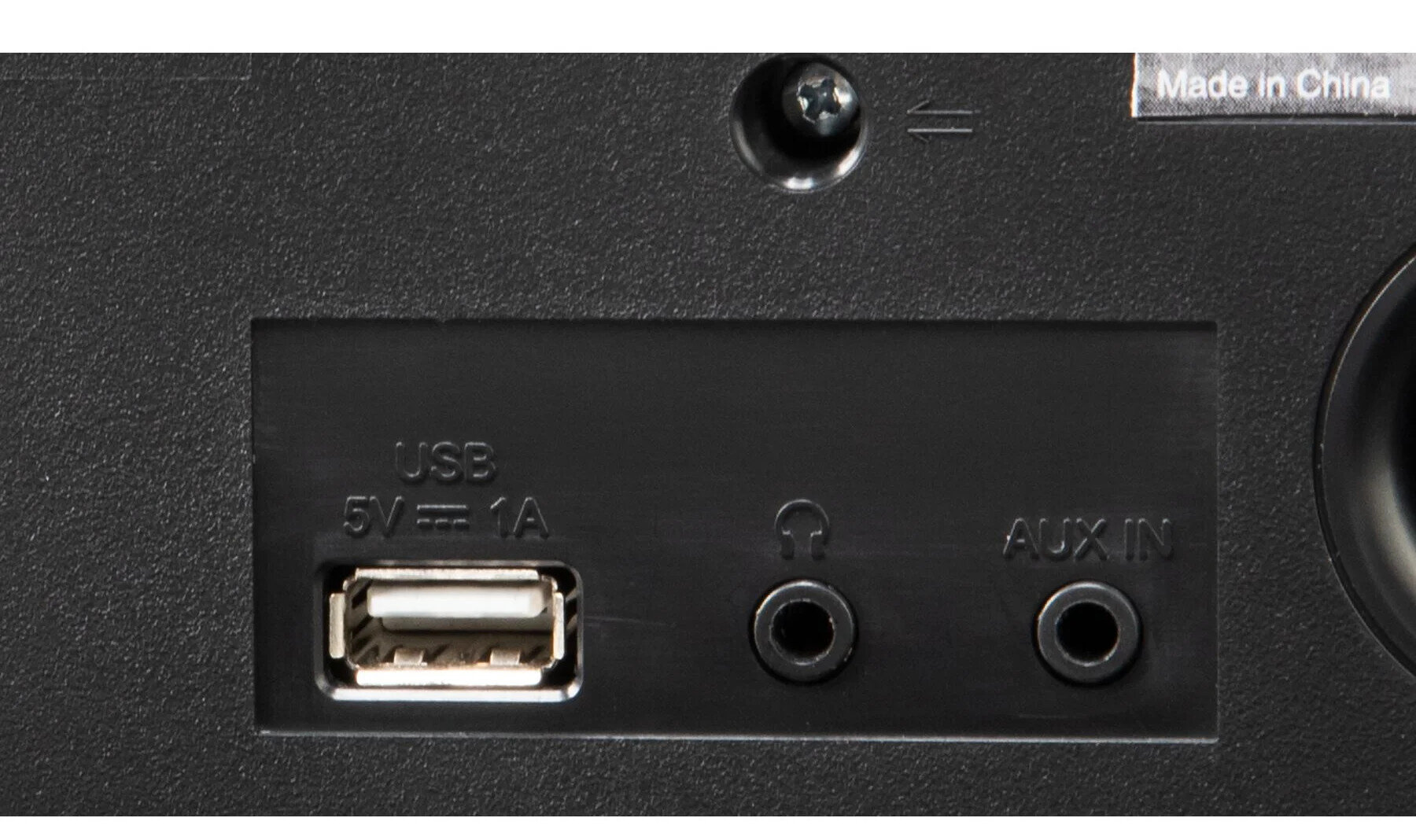 Zbliżenie tylnego panelu czarnego głośnika z portami USB, aux in i słuchawkowym oraz śrubą.