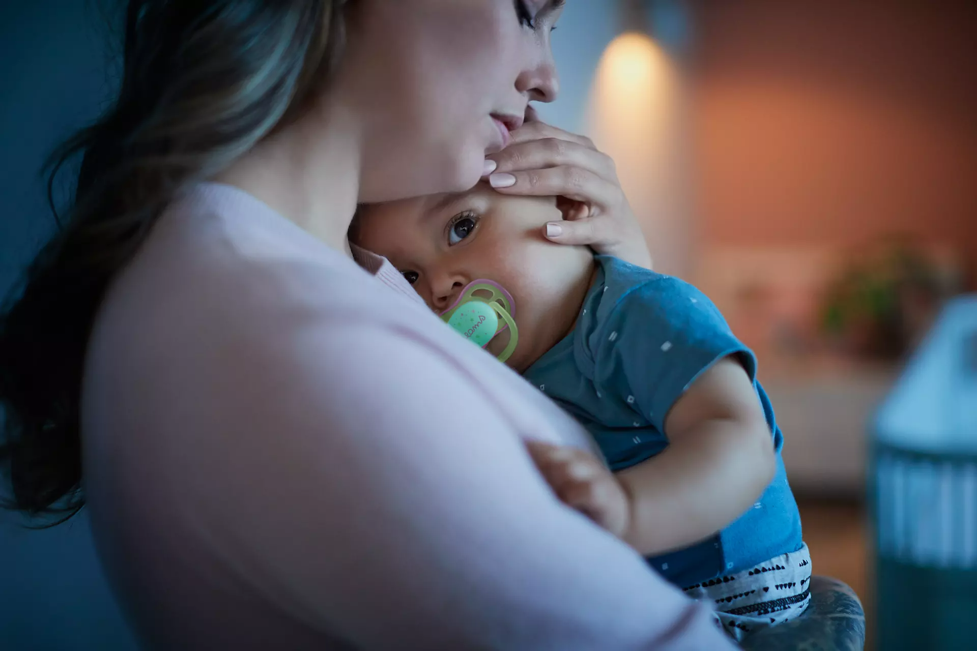 Anya tartja a babát, a baba cumival, meleg és intim jelenet.