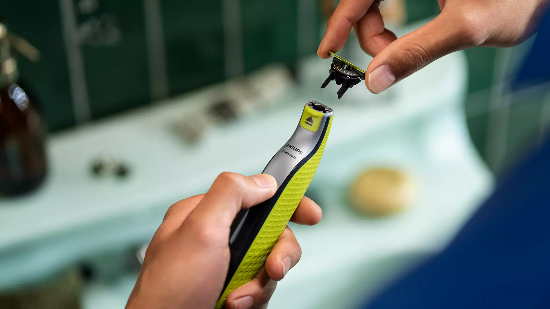 Férfi borotva pengét cserél a mosdókagylón.