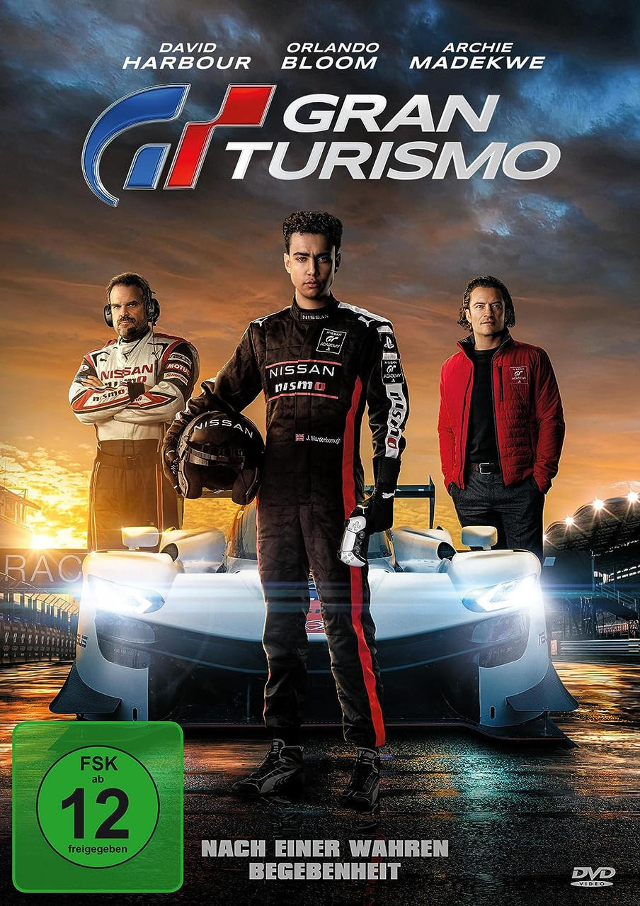 DVD-Cover des Films 'Gran Turismo', mit David Harbour, Orlando Bloom und Archie Madekwe vor einem Rennwagen.