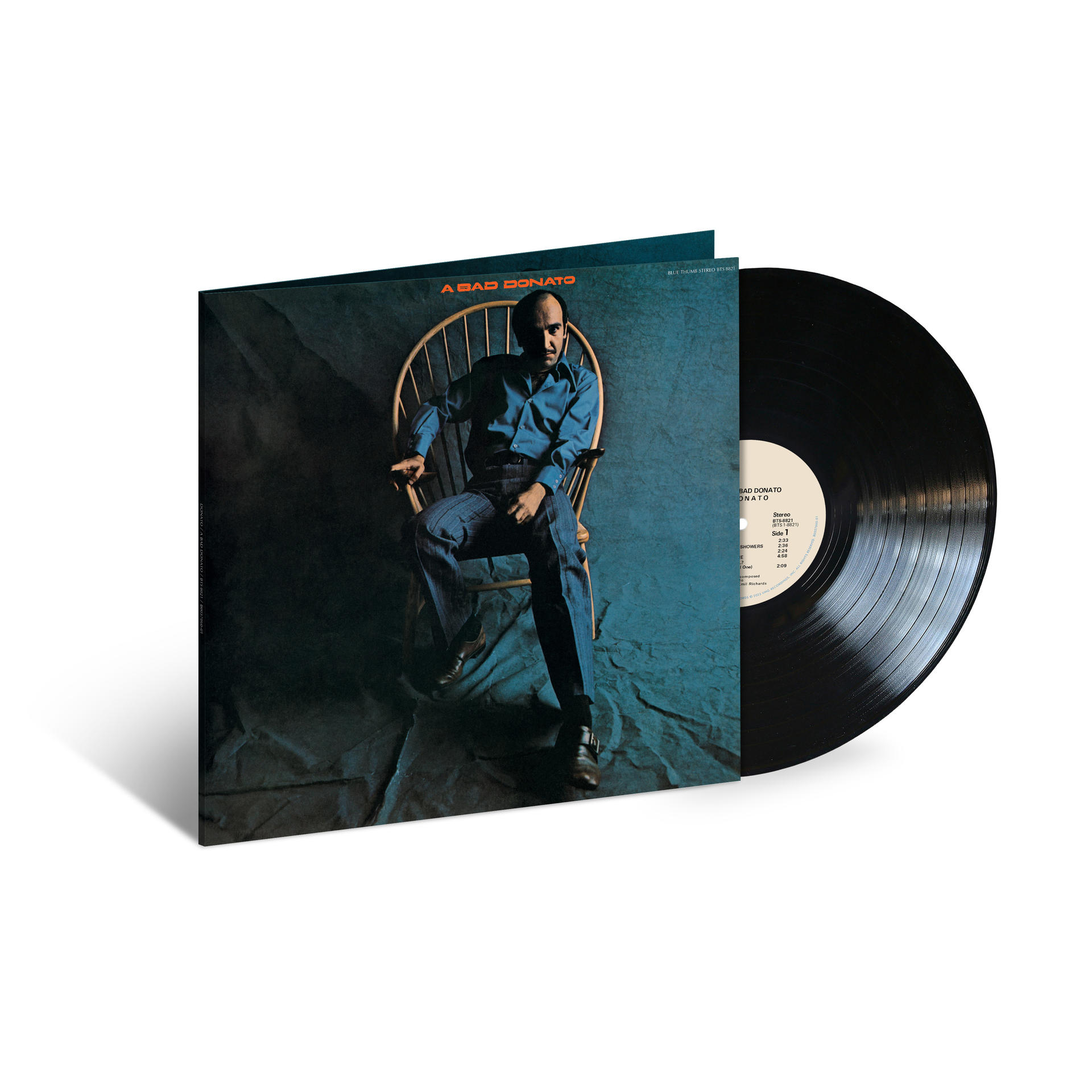 Albumcover mit einem Mann in einem Stuhl. Schwarze Schallplatte neben dem Cover.