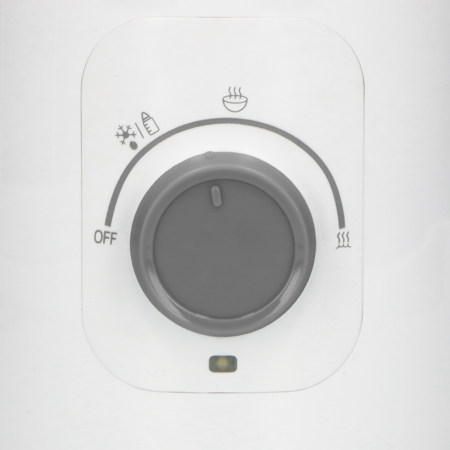 Close-up of a white control panel with a dial and icons for cold, off, and hot.