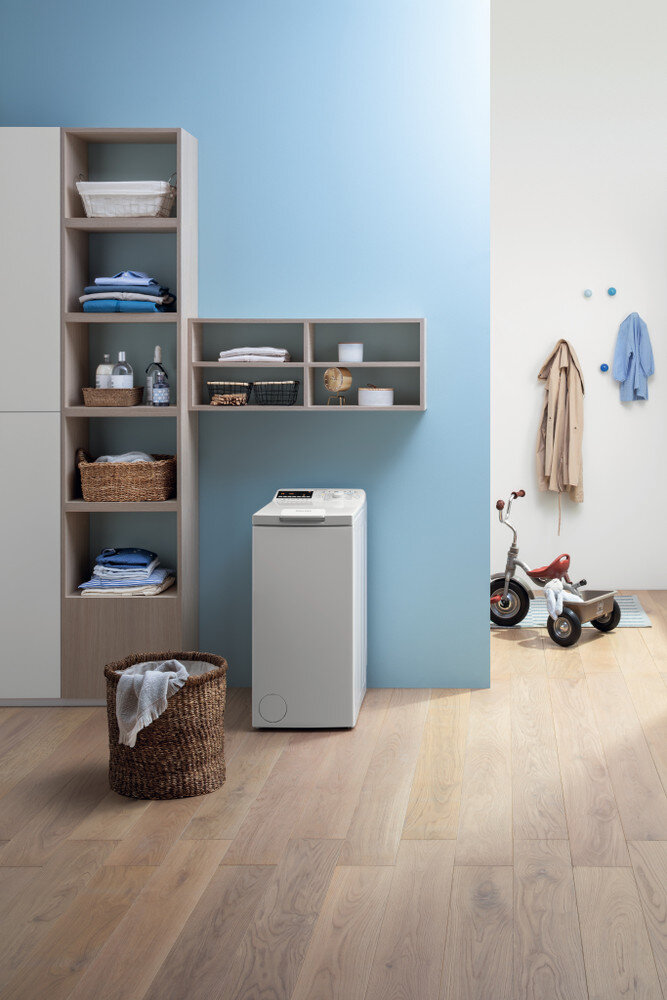 Pralnia z pralką, półkami i koszem.