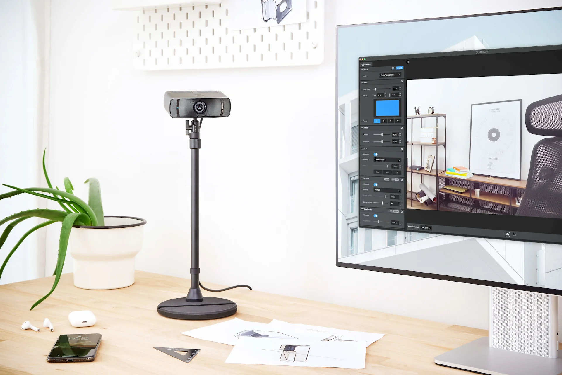 Une webcam sur un support sur un bureau avec un écran d'ordinateur affichant une page web.