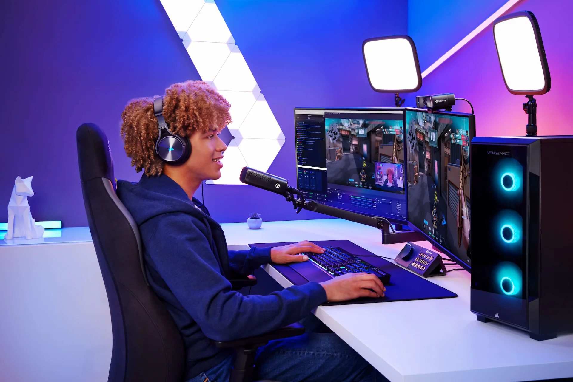 Jeune joueur sur un bureau avec PC, lumières, micro et casque. Jouant sur deux écrans.