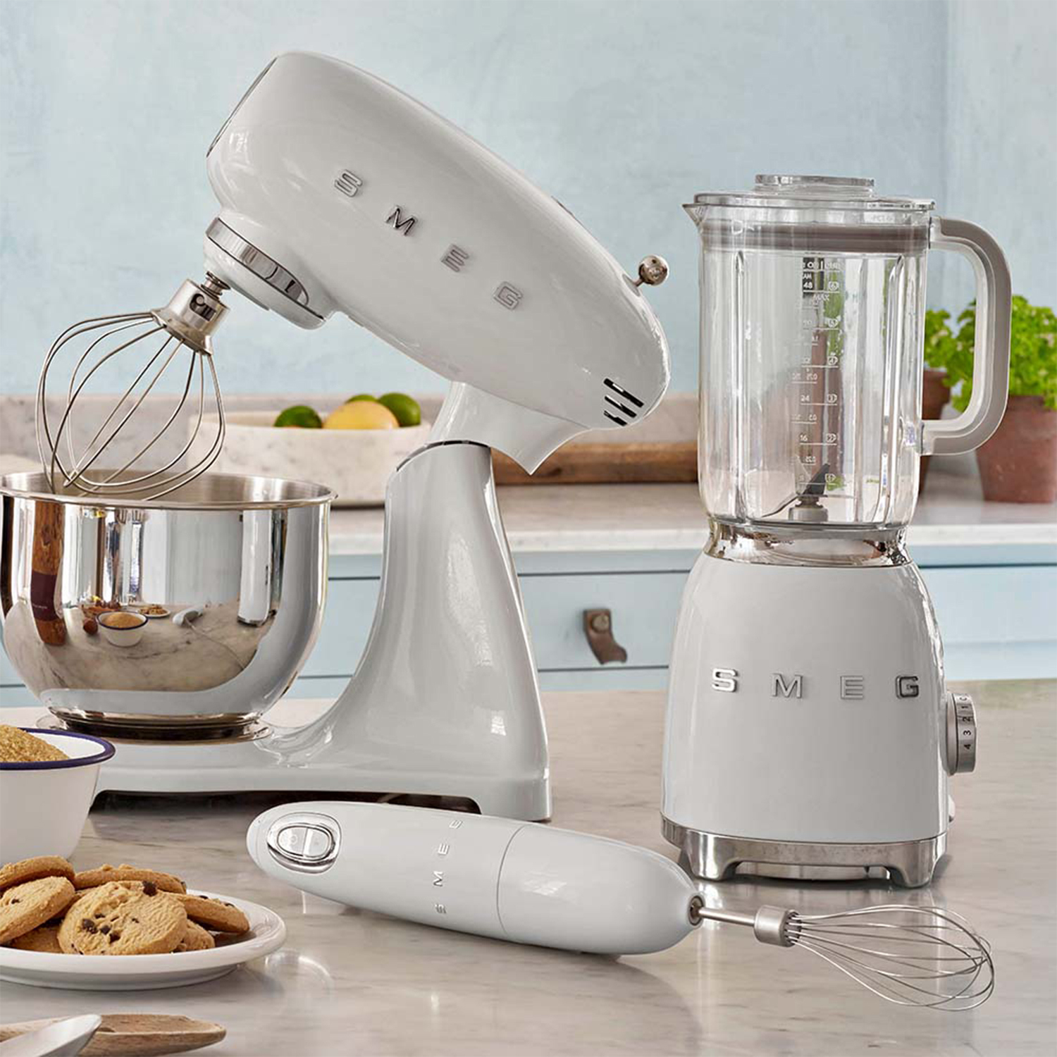 Un set di elettrodomestici da cucina SMEG bianchi, tra cui un'impastatrice, un frullatore e un frullatore a immersione.
