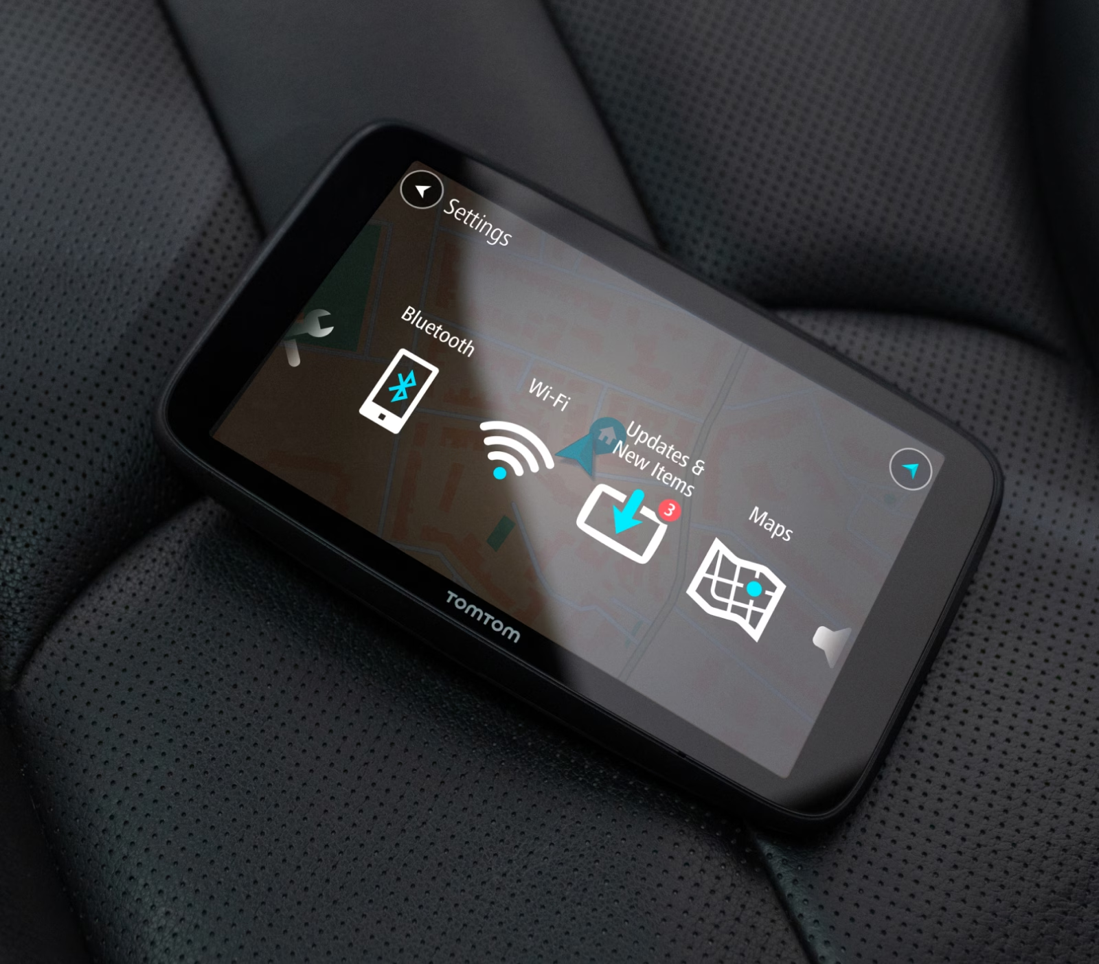 Un dispositivo GPS TomTom su un sedile auto. Lo schermo del dispositivo mostra impostazioni e mappe.