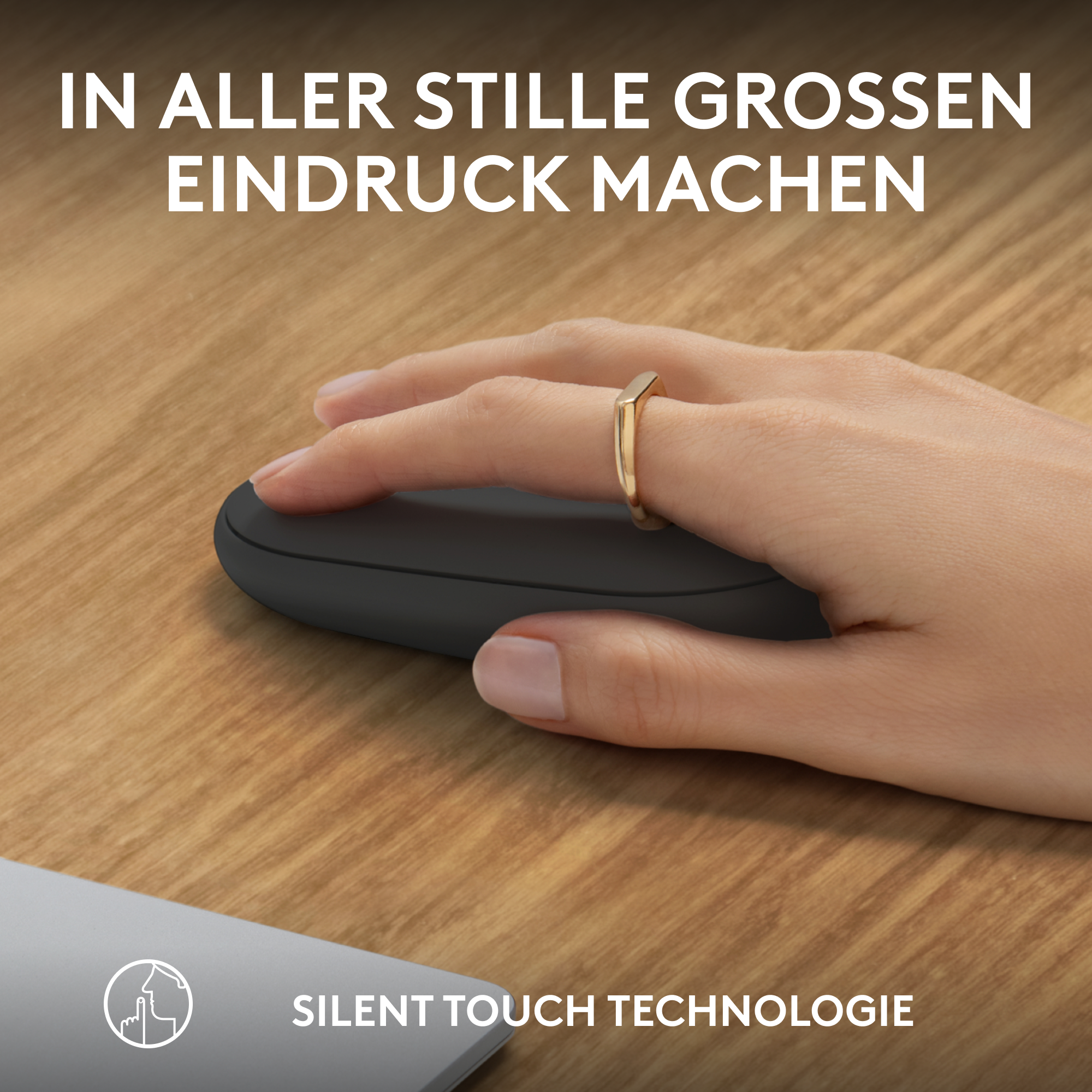 Hand mit Ring auf einer Maus, Text unten: Silent Touch Technologie.