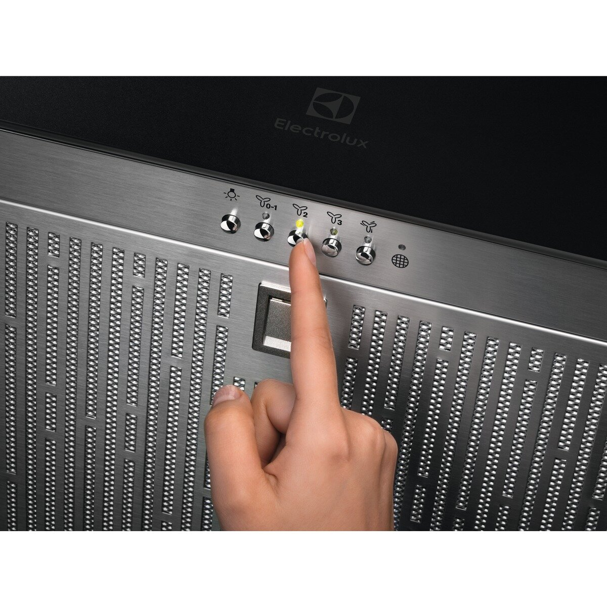 Ręka naciskająca przycisk na panelu sterowania okapu ze stali nierdzewnej.