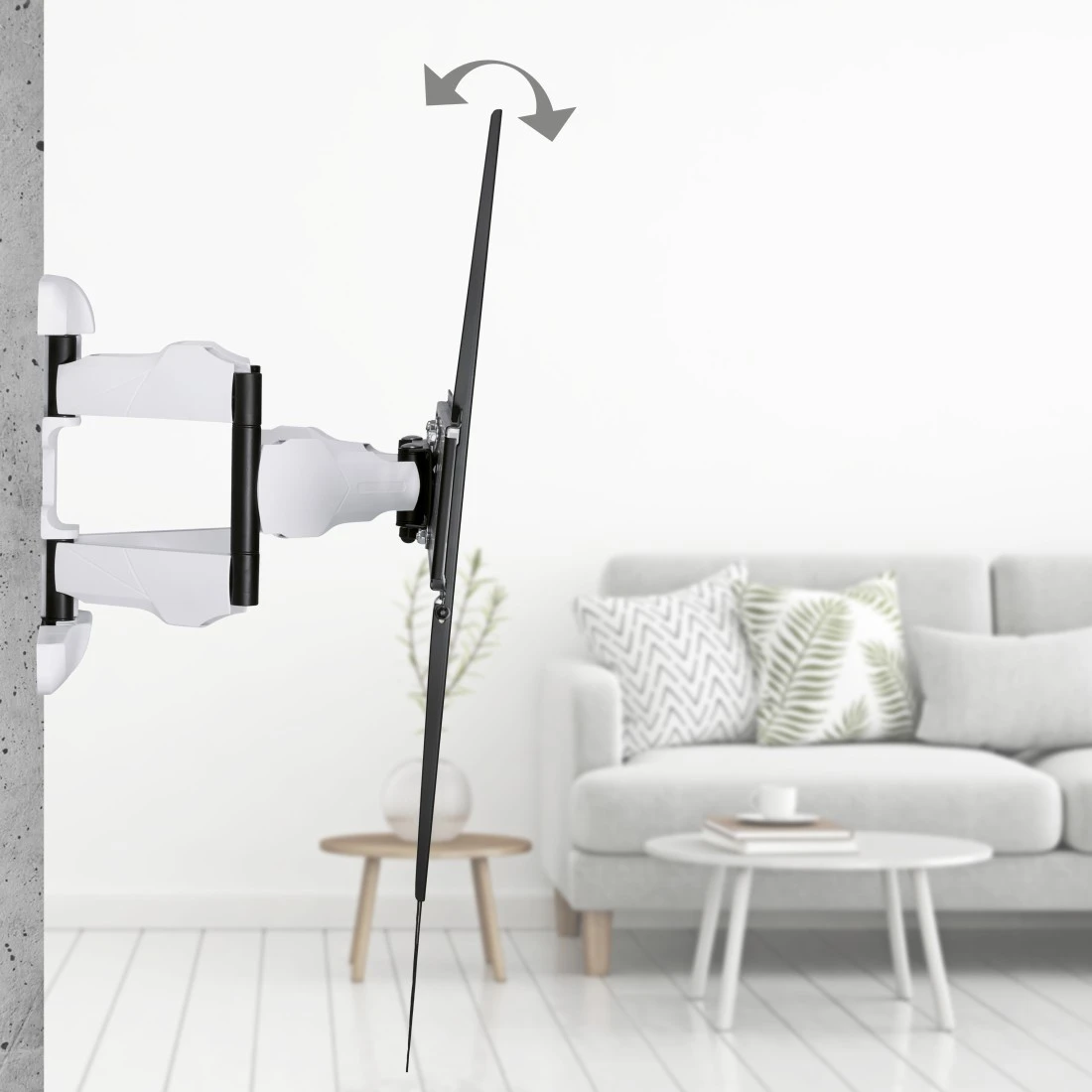 TV-Halterung, weiß, an einer Betonwand, mit einem TV-Bildschirm befestigt. Sofa und Tisch im Hintergrund.