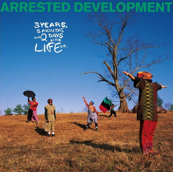 Album borító: Arrested Development. Emberek csoportja egy mezőn, kék ég és egy fa.