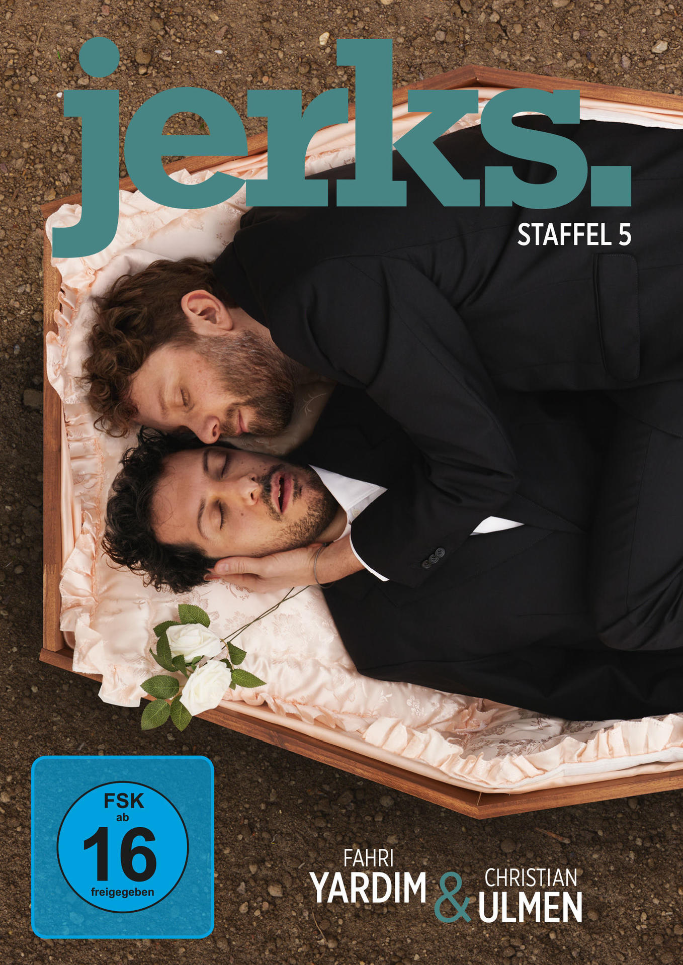 DVD-Cover von Jerks, Staffel 5. Zwei Männer in Anzügen liegen in einem Sarg, eine Blume.