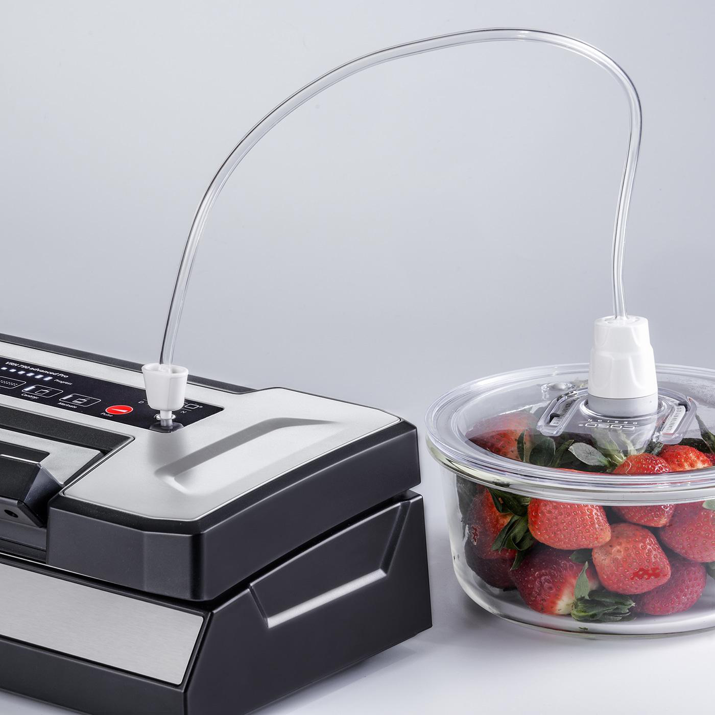 Vakuumversiegelungsgerät mit einem durchsichtigen Schlauch, der mit einer Glasschüssel mit Erdbeeren verbunden ist.