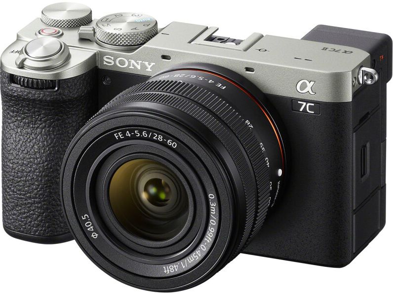 Fotocamera Sony Alpha 7C con obiettivo, corpo nero e argento. L'obiettivo è nero con scritte.
