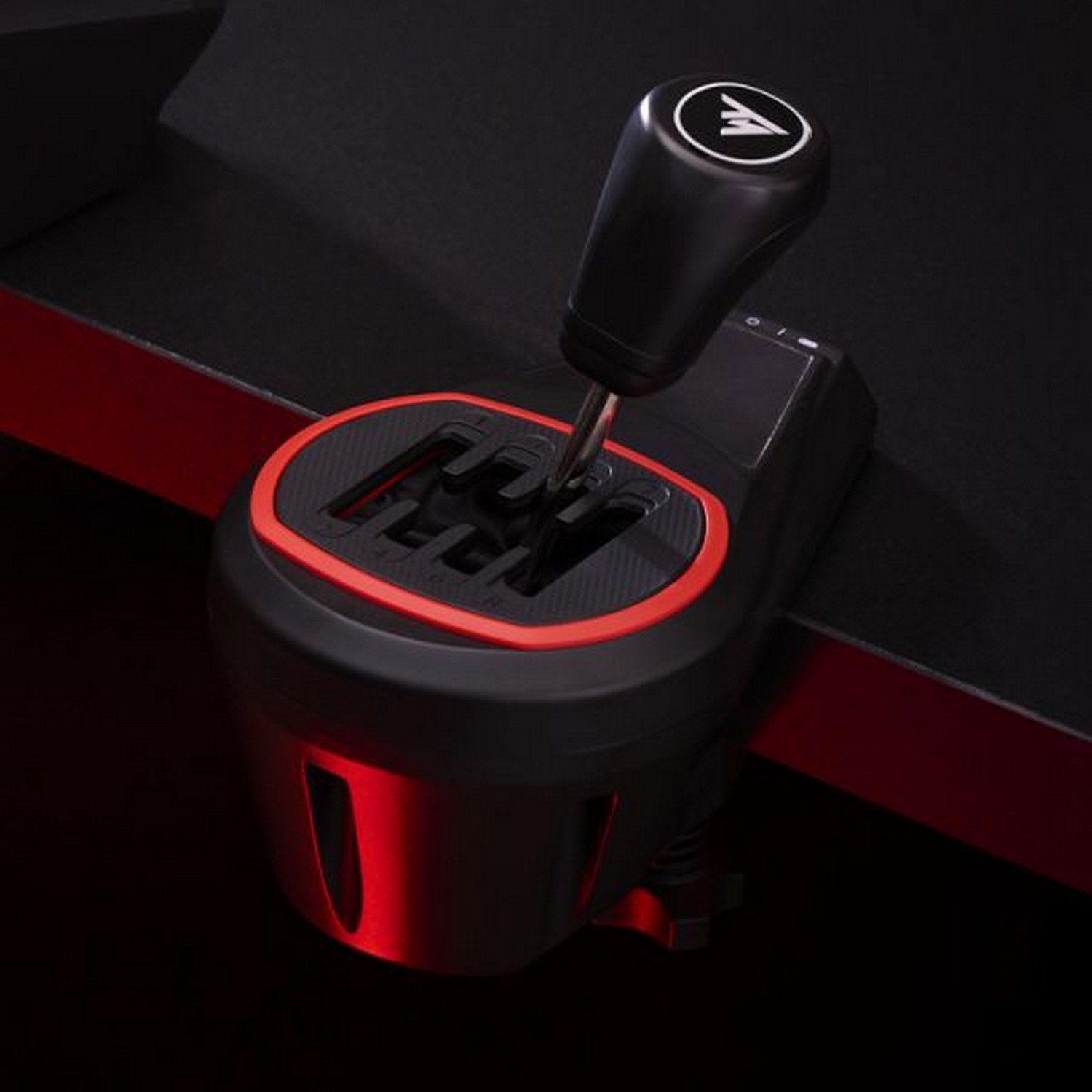 Gear shift with a logo on top. Red light is at the bottom.