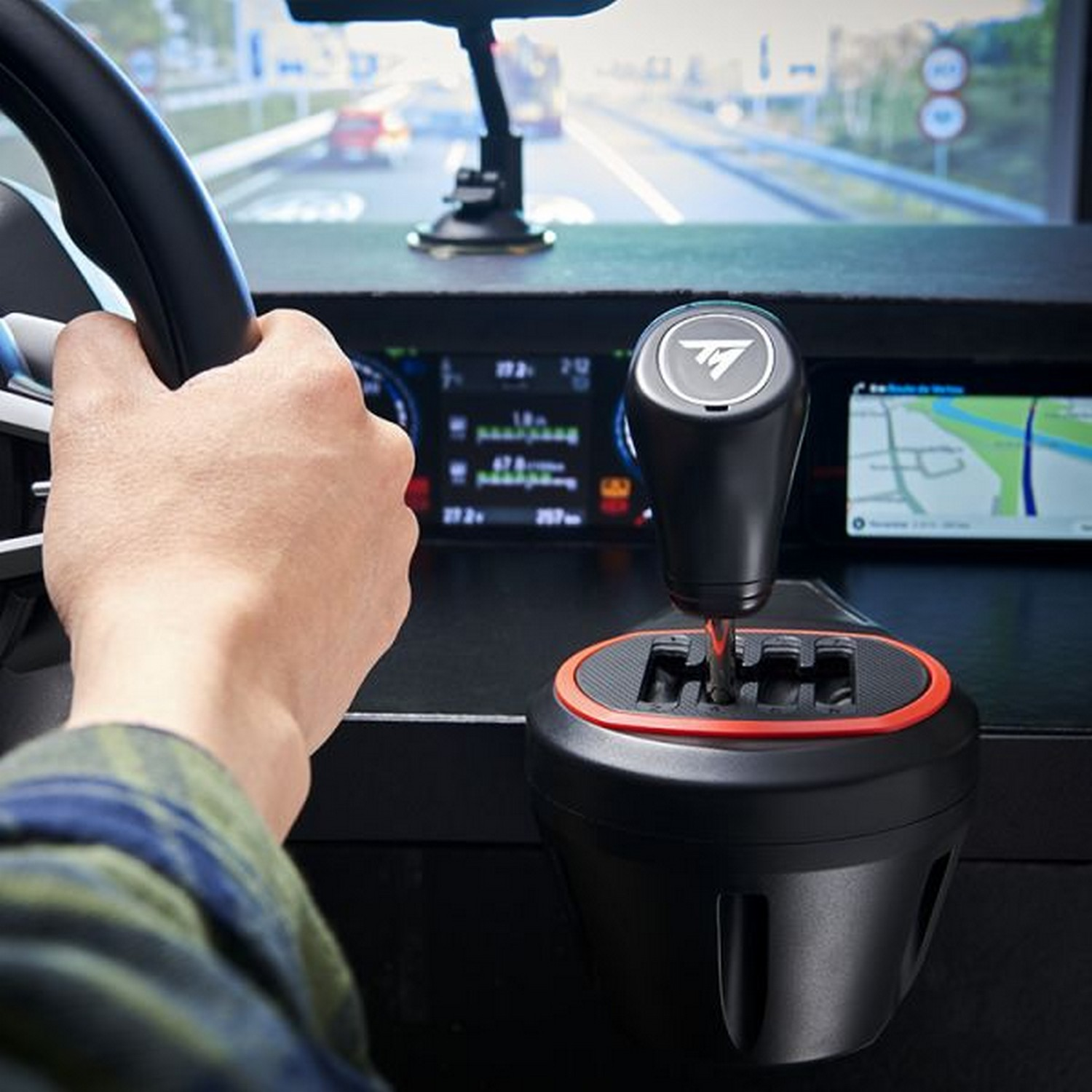 Person holding a gear shift, game screen in background.