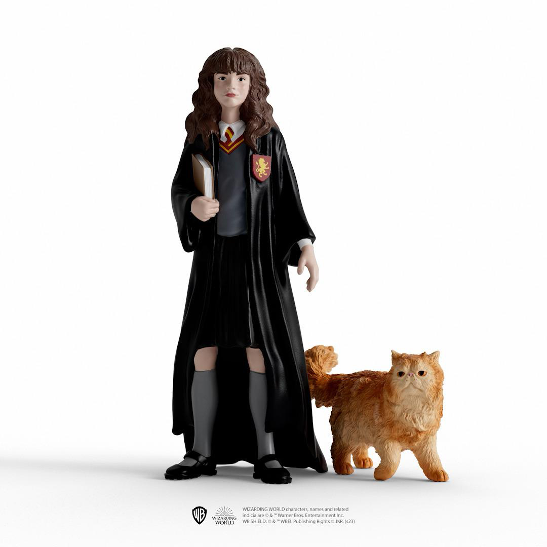 Hermine Granger Figur mit Buch und Katze. Sie trägt einen schwarzen Umhang und Uniform.