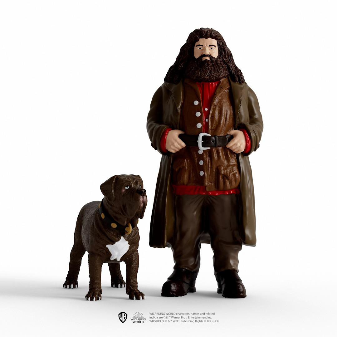 Statue von Hagrid mit seinem Hund. Hagrid trägt einen braunen Mantel und ein rotes Hemd.