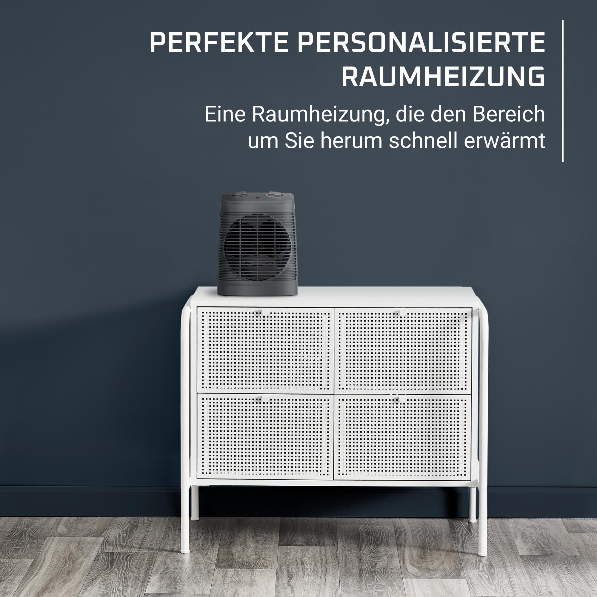 Ein kleiner, schwarzer Elektroheizer auf einem weißen Schrank vor einer dunkelblauen Wand.