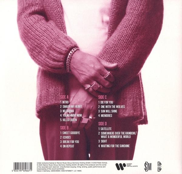 Albumcover mit einer Person in einem rosa Pullover, verschränkten Armen und Album-Trackliste.