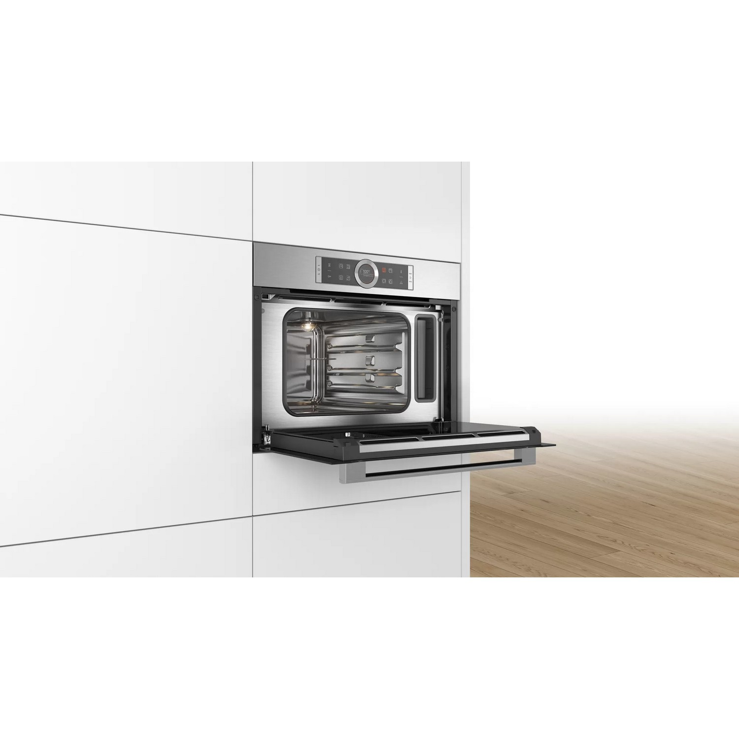 Four encastré avec porte ouverte dans une cuisine blanche. Intérieur en acier inoxydable.