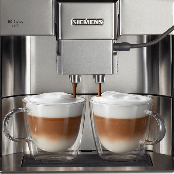 Espresso makinesi, kahveyi cam fincanlara dağıtıyor.