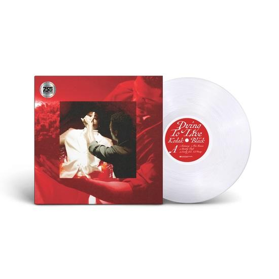 Piros album borító egy fehér bakelit lemezzel. Fehér háttér.