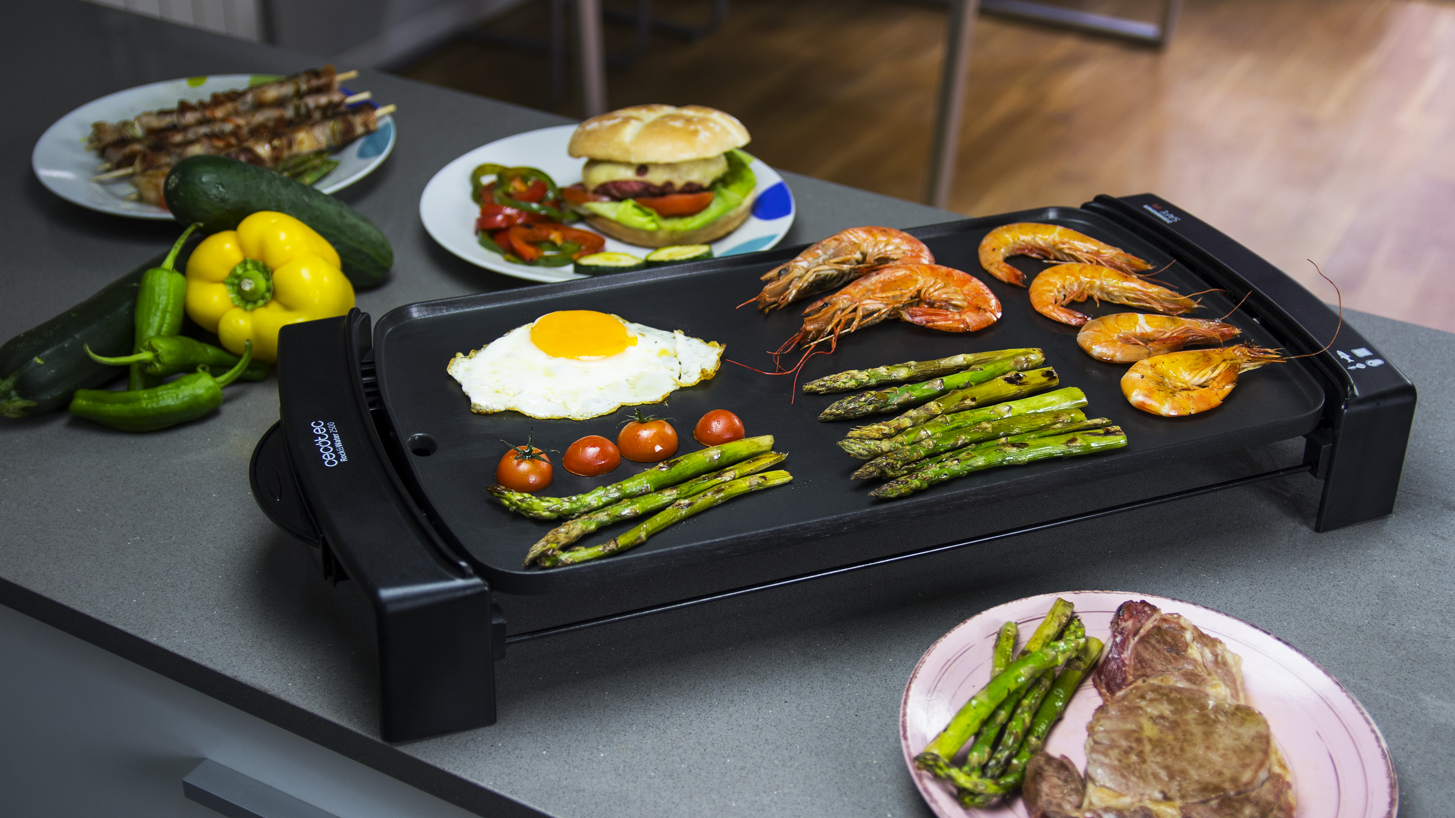 Una selección de comida a la parrilla sobre una mesa: carne, espárragos y brochetas.