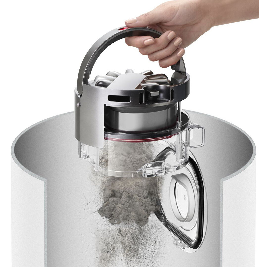 Ręka opróżniająca kurz z odkurzacza Dyson. Komora na kurz jest przezroczysta.