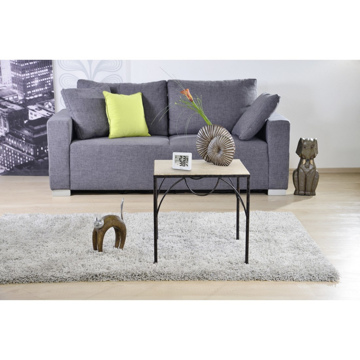Salón con sofá gris, mesa y decoración.