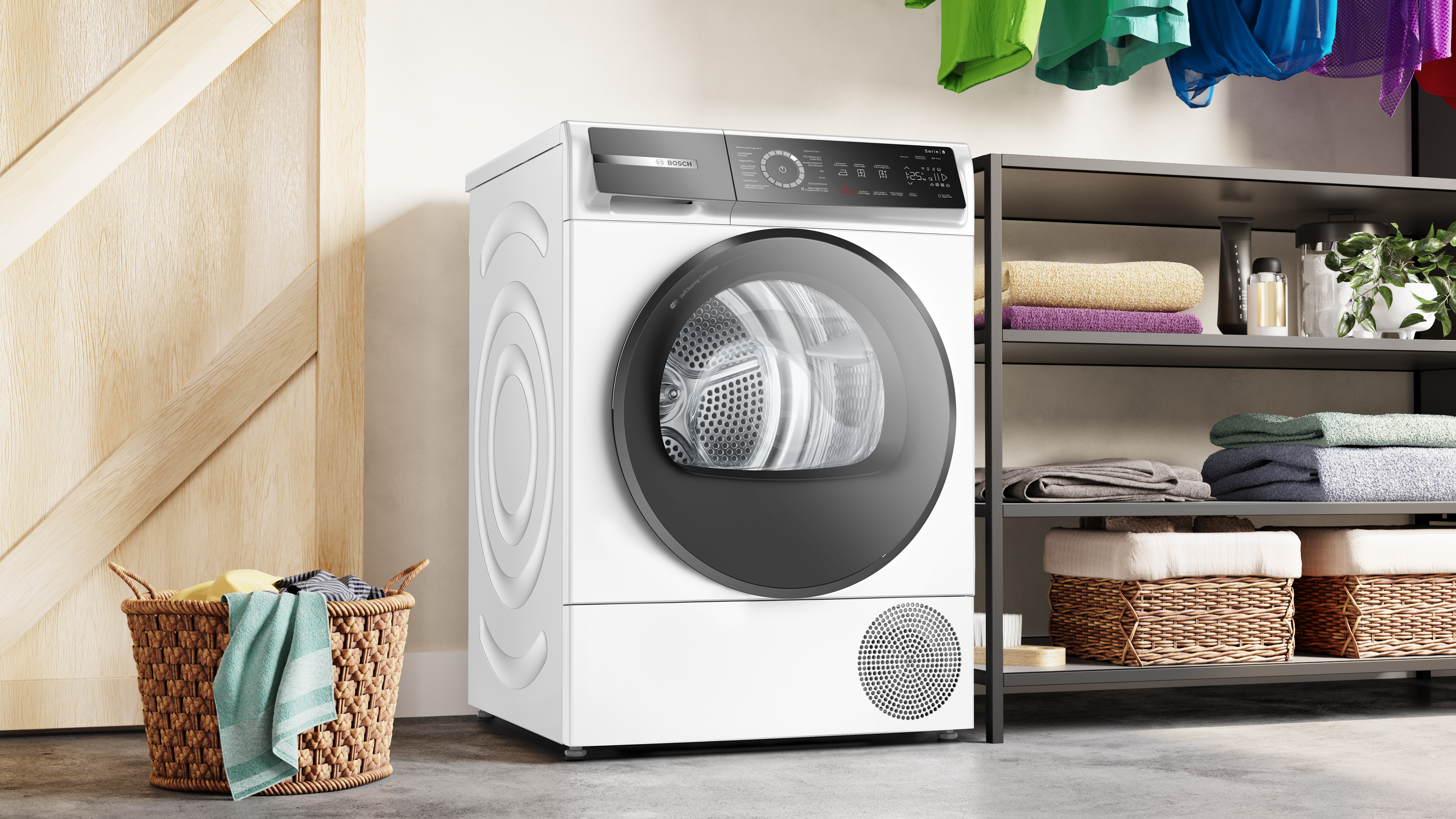Sèche-linge blanc. Panier avec serviettes à gauche. Étagères avec objets à droite. Buanderie.