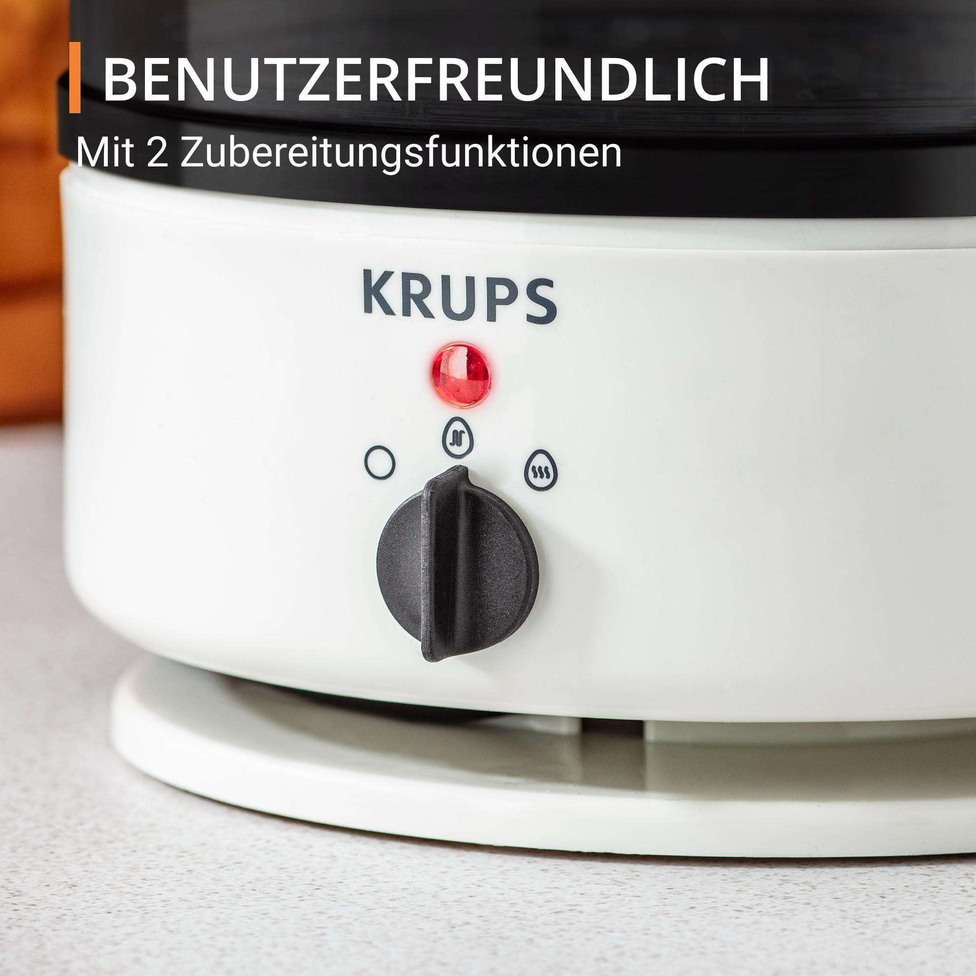 Nahaufnahme eines weißen Krups Kaffeeautomaten mit rotem Licht, Drehknopf und zwei Tasten.