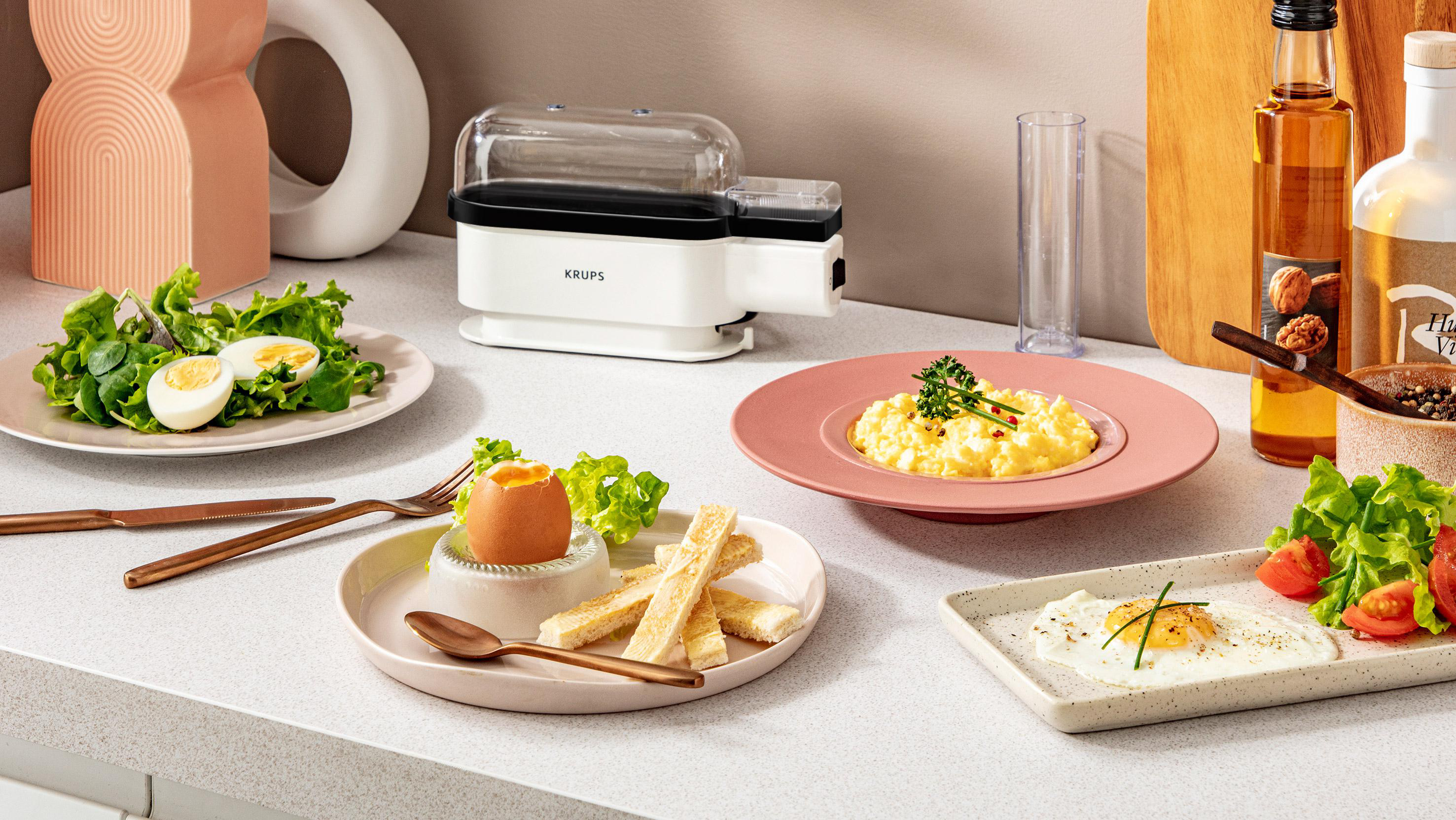 Ein Tischgedeck mit verschiedenen Frühstücksspeisen, darunter Eier, Toast und Obst.