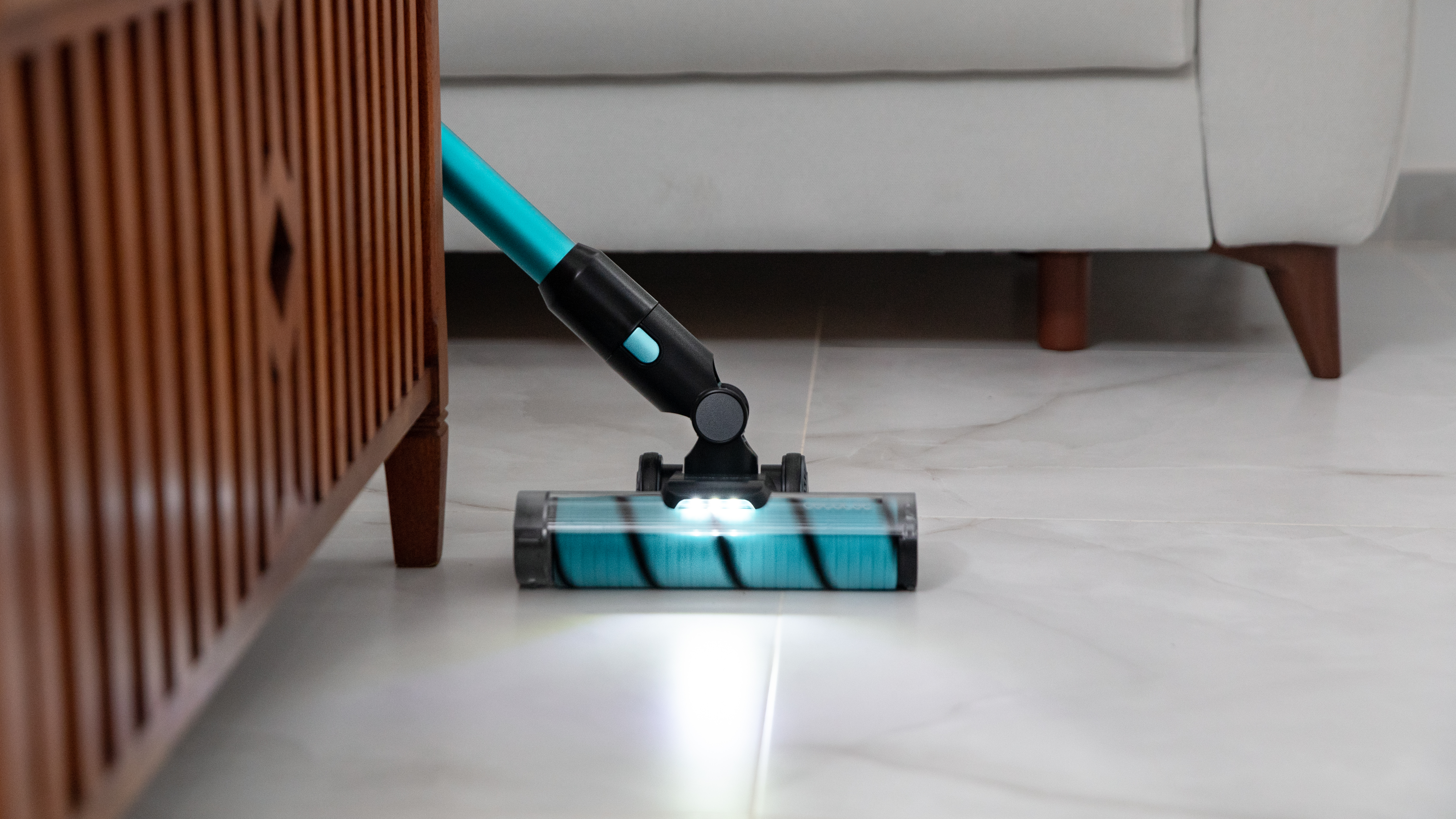 Cabezal de aspiradora limpiando cerca de un mueble de madera.