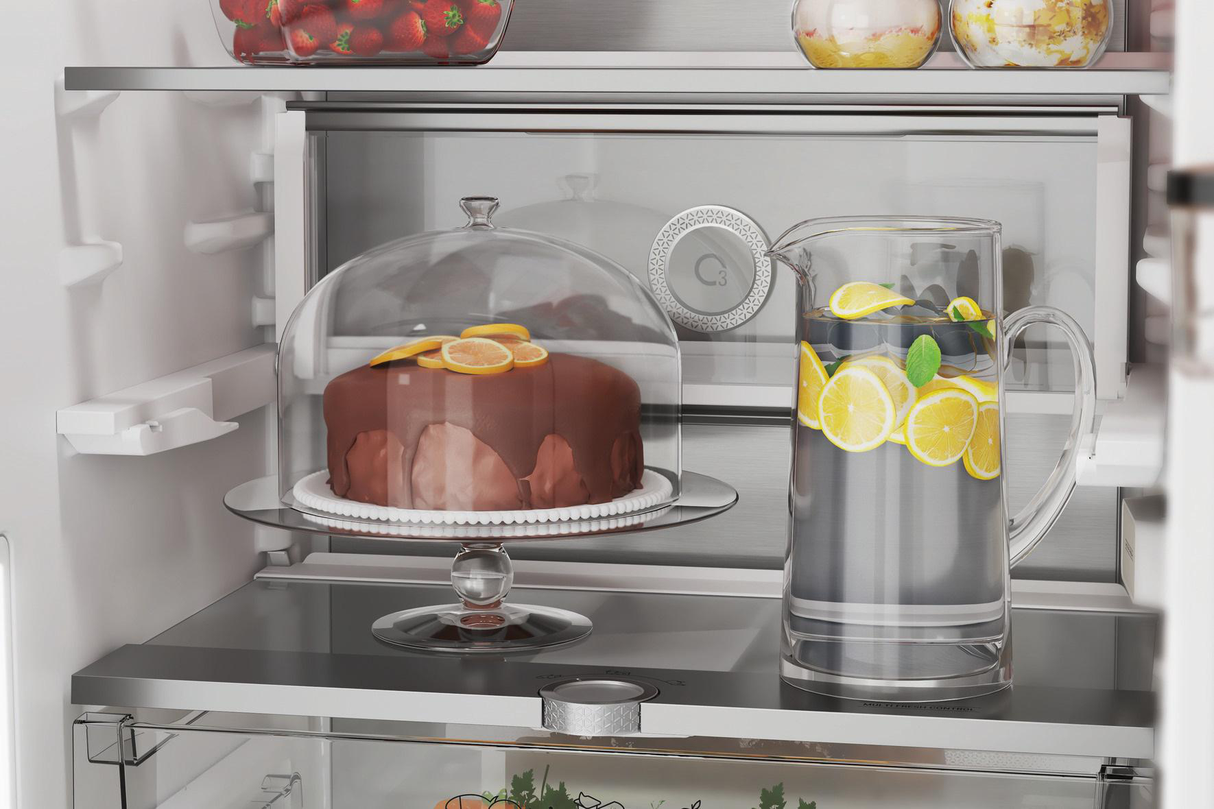 Im Kühlschrank, ein Kuchen in einer Glaskuppel und ein Krug mit Zitronenwasser.