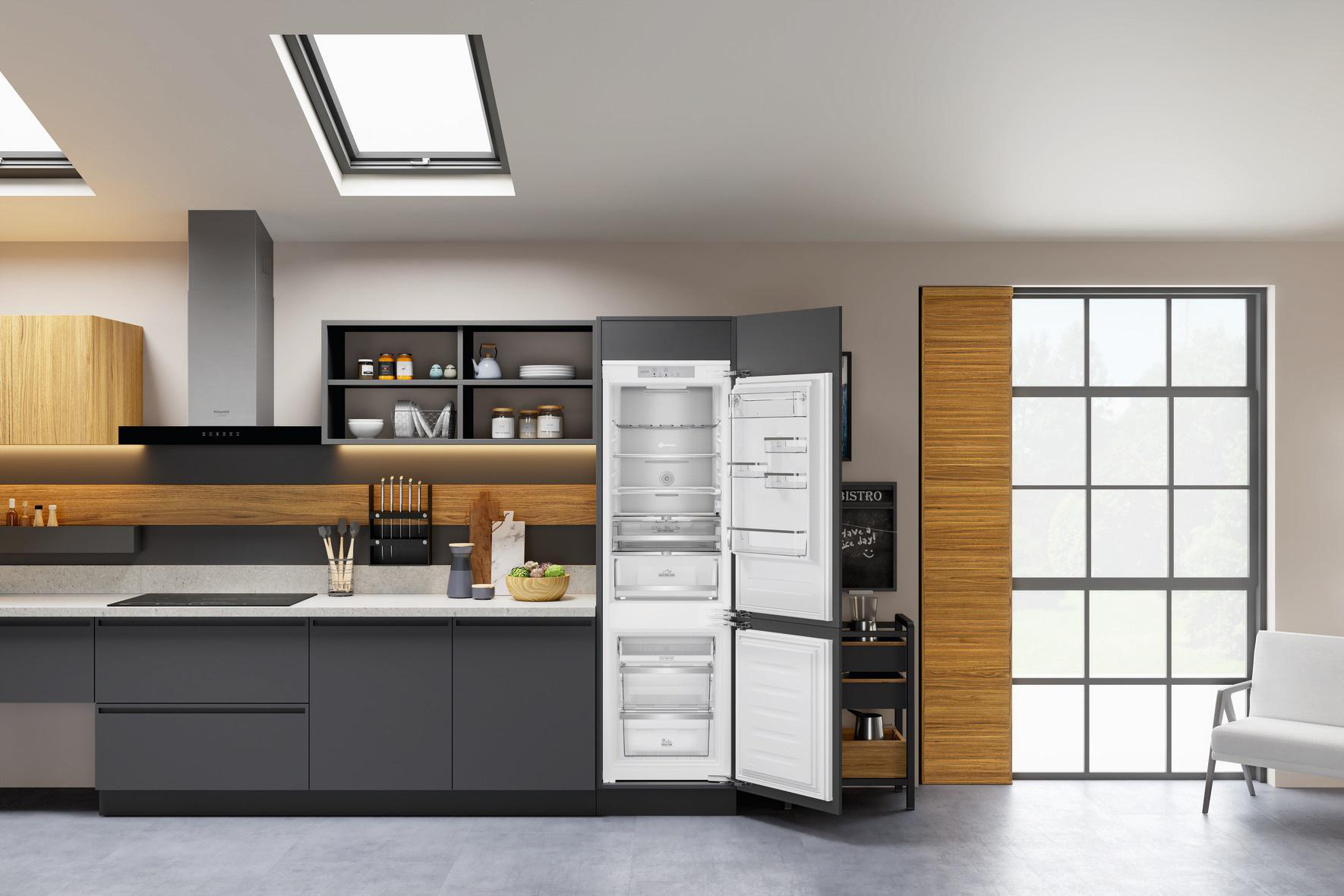 Moderne Küche mit offenem Kühlschrank, der Regale, Schubladen und Lebensmittel zeigt.