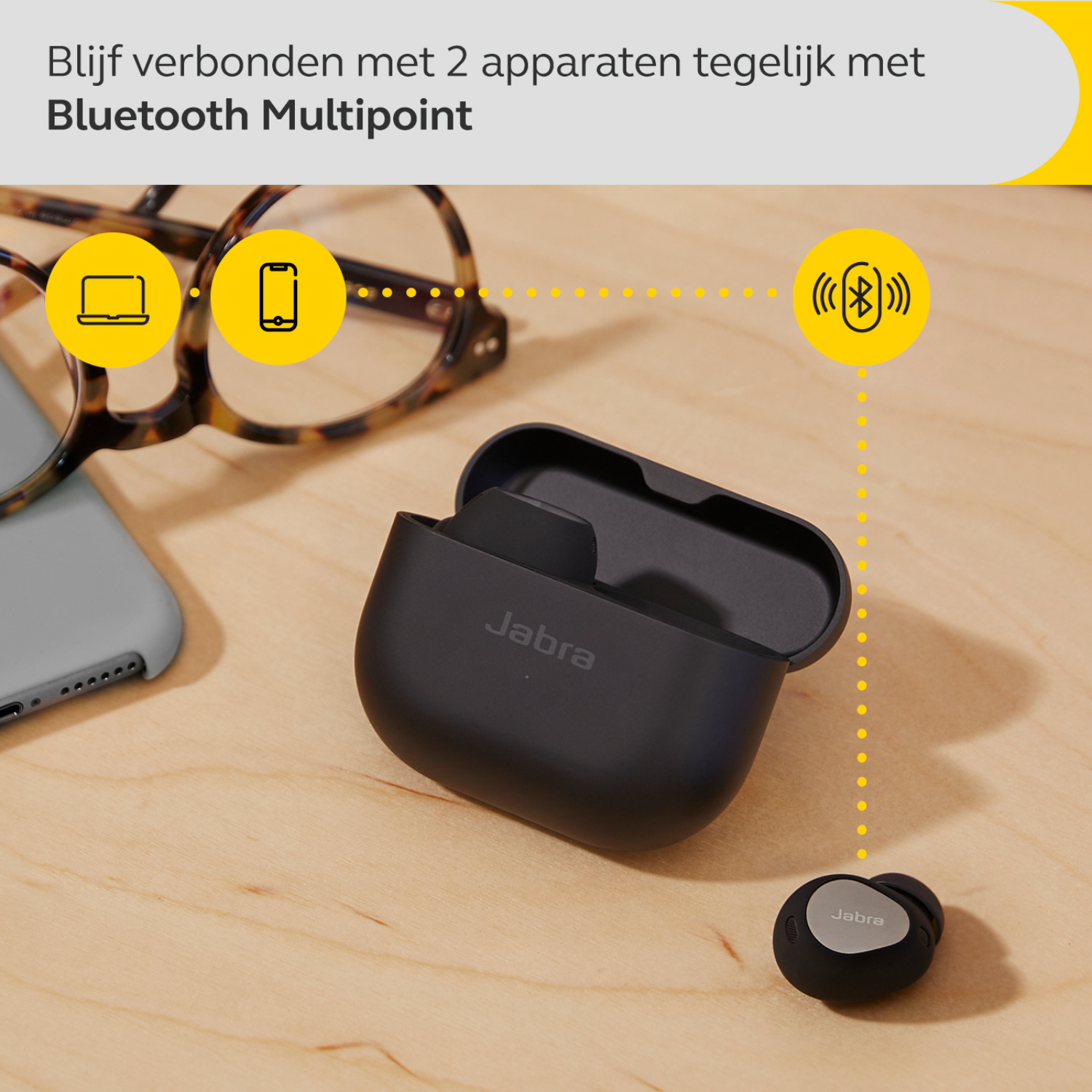 Zwarte Jabra oordopjes in een oplaadcase op een houten oppervlak.