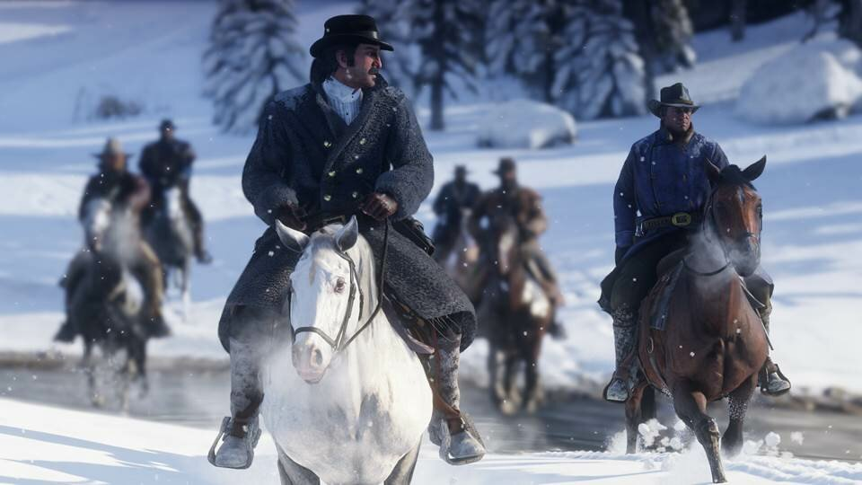 Scena z Red Dead Redemption 2. Mężczyźni na koniach w zaśnieżonym otoczeniu. Zimowa sceneria z drzewami i śniegiem.