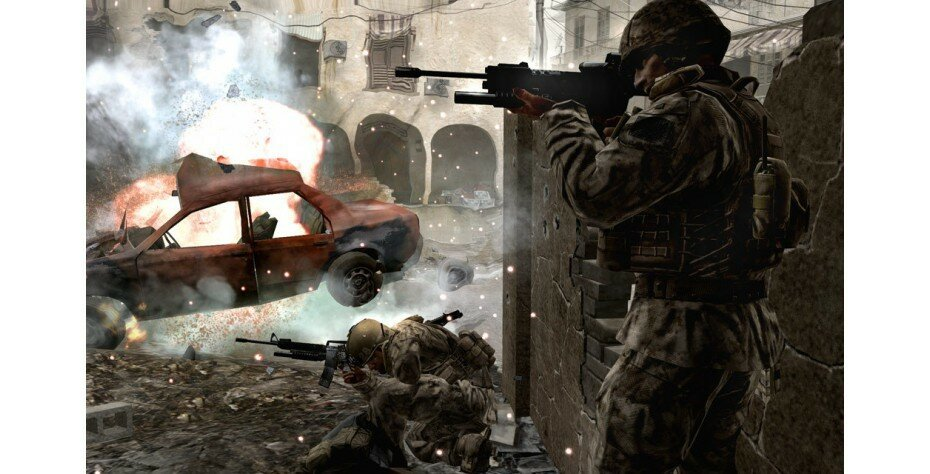 Scena z gry Call of Duty. Żołnierze w walce, z zniszczonym samochodem i eksplozją. Otoczenie zniszczone wojną.