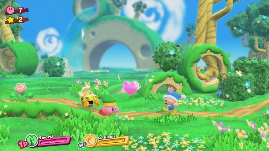 Kirby i inne postacie w kolorowym, kreskówkowym krajobrazie z przeszkodami.