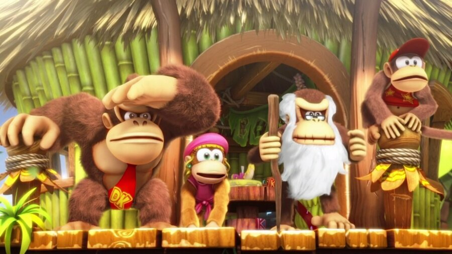 Postacie Donkey Kong stojące przed chatą.