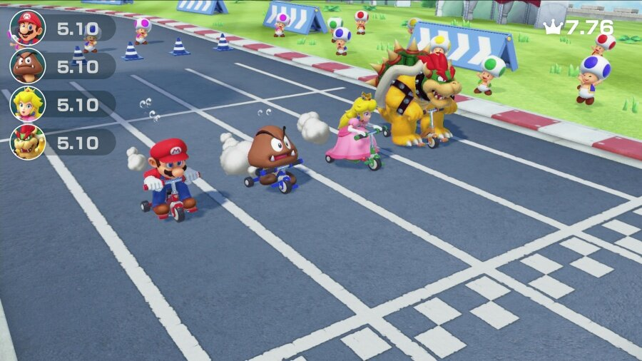 Scena z Mario Kart: Mario, Peach, Bowser jadą na skuterach. Widoczny tor, widzowie i linia mety.