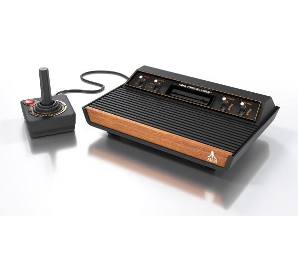 Konsola do gier Atari z joystickiem, czarna i brązowa. Joystick ma czerwony przycisk. Konsola jest czarna i brązowa.
