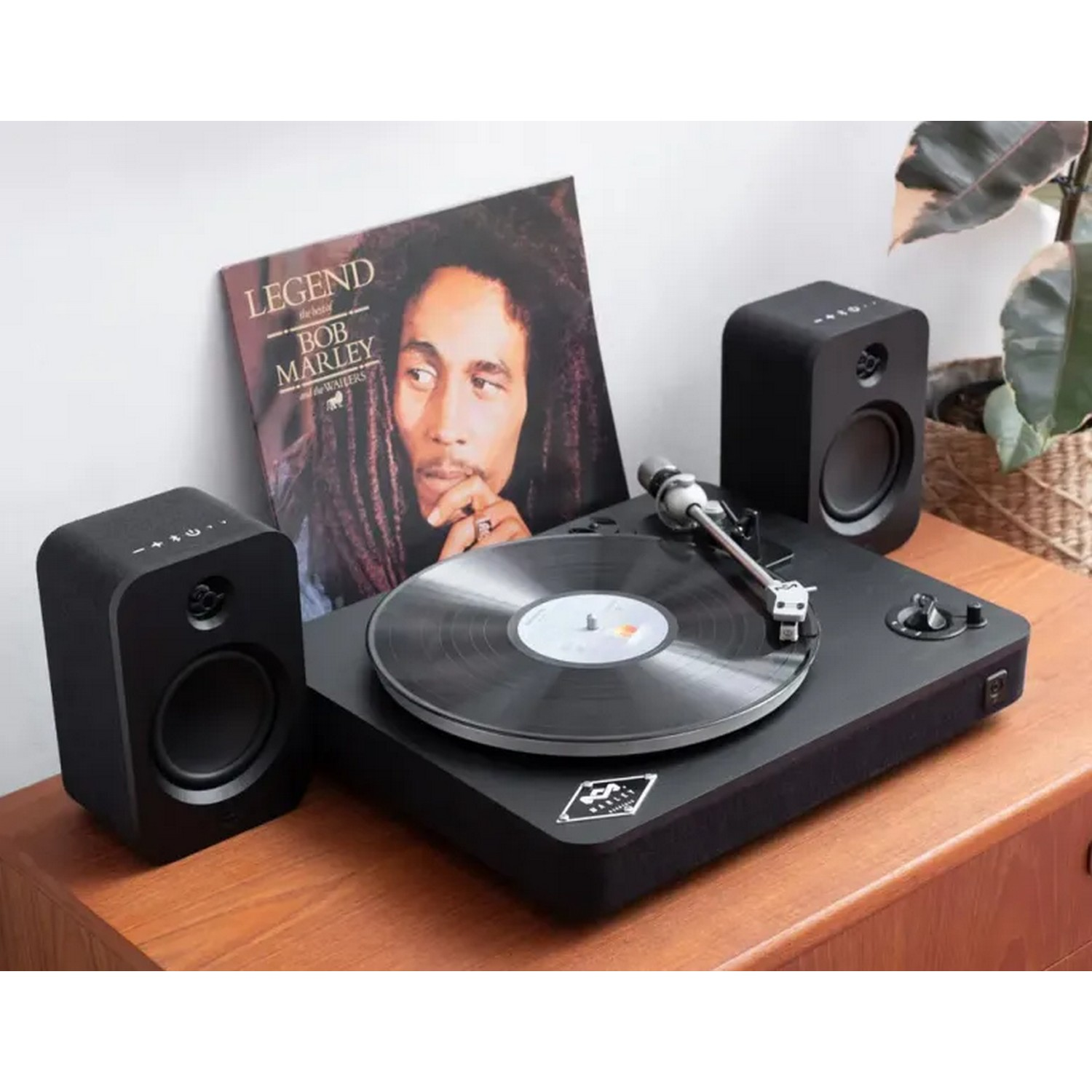 Platine vinyle avec un album de Bob Marley et deux enceintes.